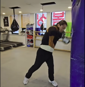 복싱 백글러브를 착용하고 샌드백을 타격하는 모습